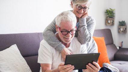 Senior elderly couple looking at online tablet